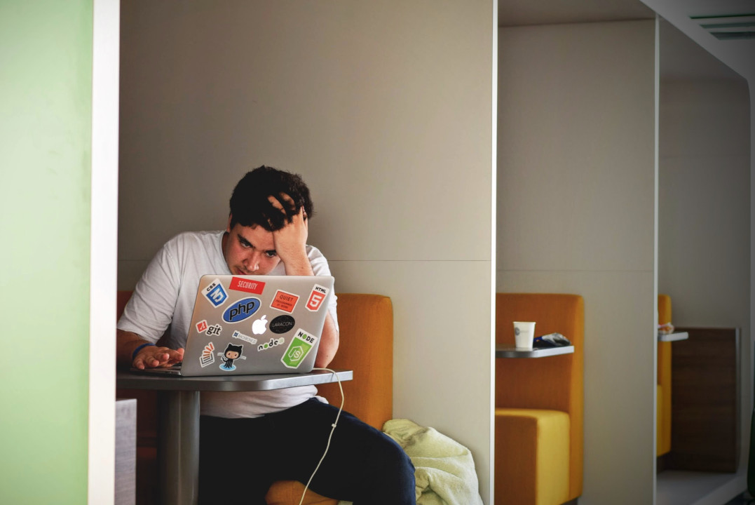 A stressed man working on his laptop